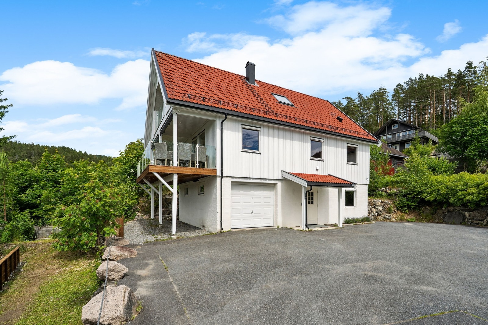 Velholdt enebolig med oppgradert fasade, med terrasse med glassrekkverk og romslig asfaltert gårdsplass. Galleribilde