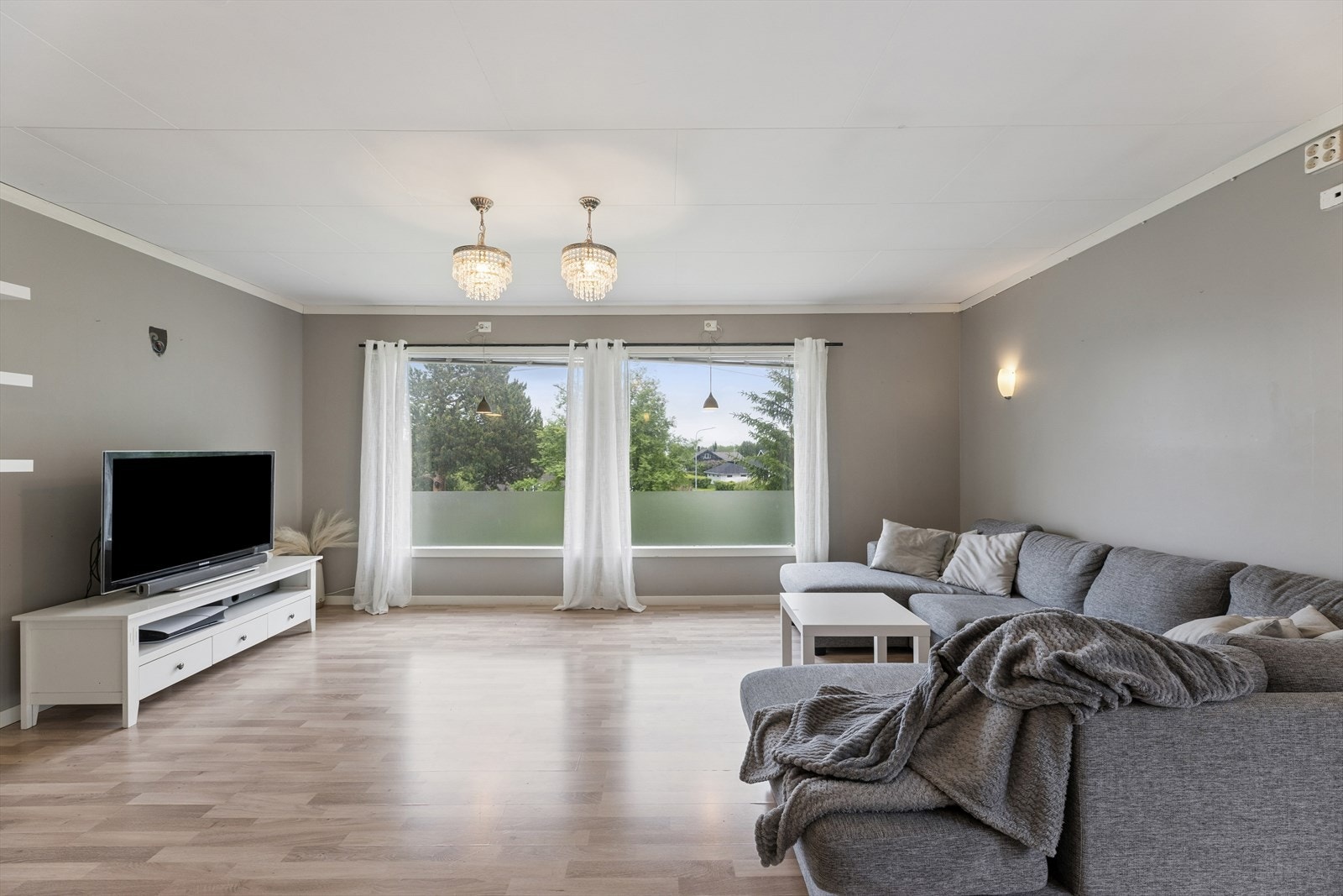 Store vindusflater gir rikelig med naturlig lys inn i stuen. Galleribilde
