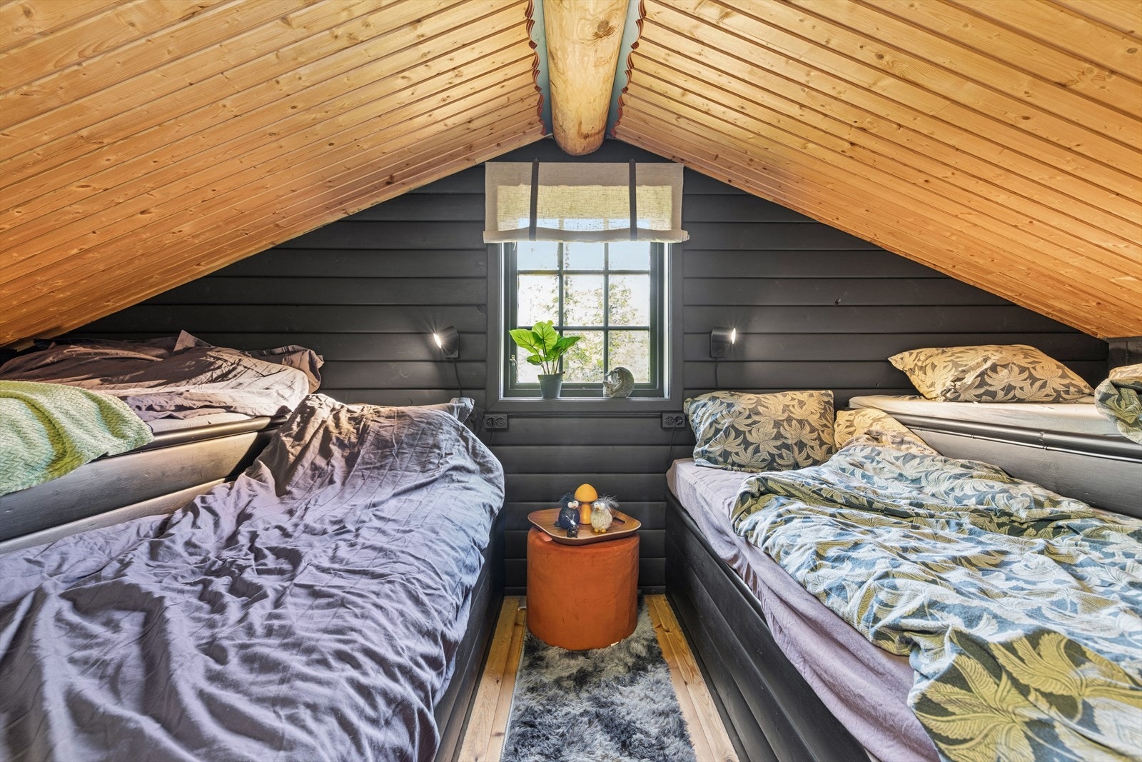 Fra stuen fører en trapp opp til en lun og koselig hems. Her er det god plass til overnatting, med fire plassbygde senger langs sidene. Takhøyden er opptil ca. 2 meter på det høyeste, og skråtaket gir en hyggelig atmosfære. Galleribilde