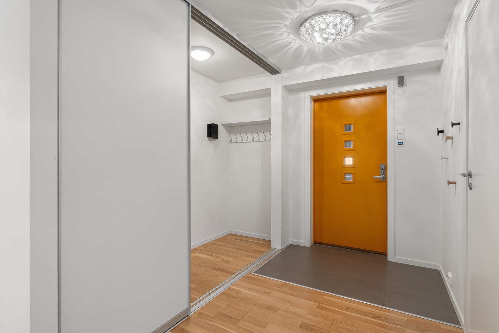 Velkommen inn! Praktisk entre med innbygd skyvedørsgarderobe som gir deg rikelig med plass til å henge av deg yttertøyet.