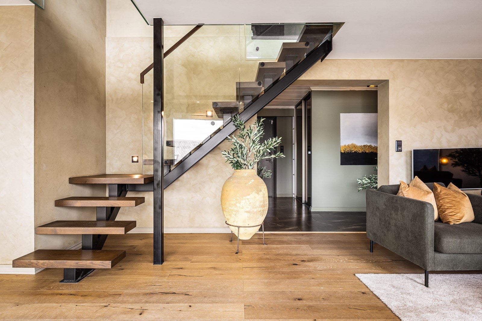 Trappen med trinn i massiv eik og glassrekkverk, forbinder de to etasjene på en elegant måte. Galleribilde