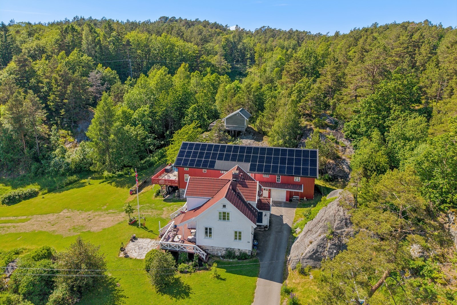 Eiendommen ligger solrikt og usjenert til innerst i privat sidevei. Annekset sees i bakgrunnen. På uthuset er det et kraftig solcelleanlegg som estimert skal kunne levere opptil 25000 kwh årlig. Galleribilde