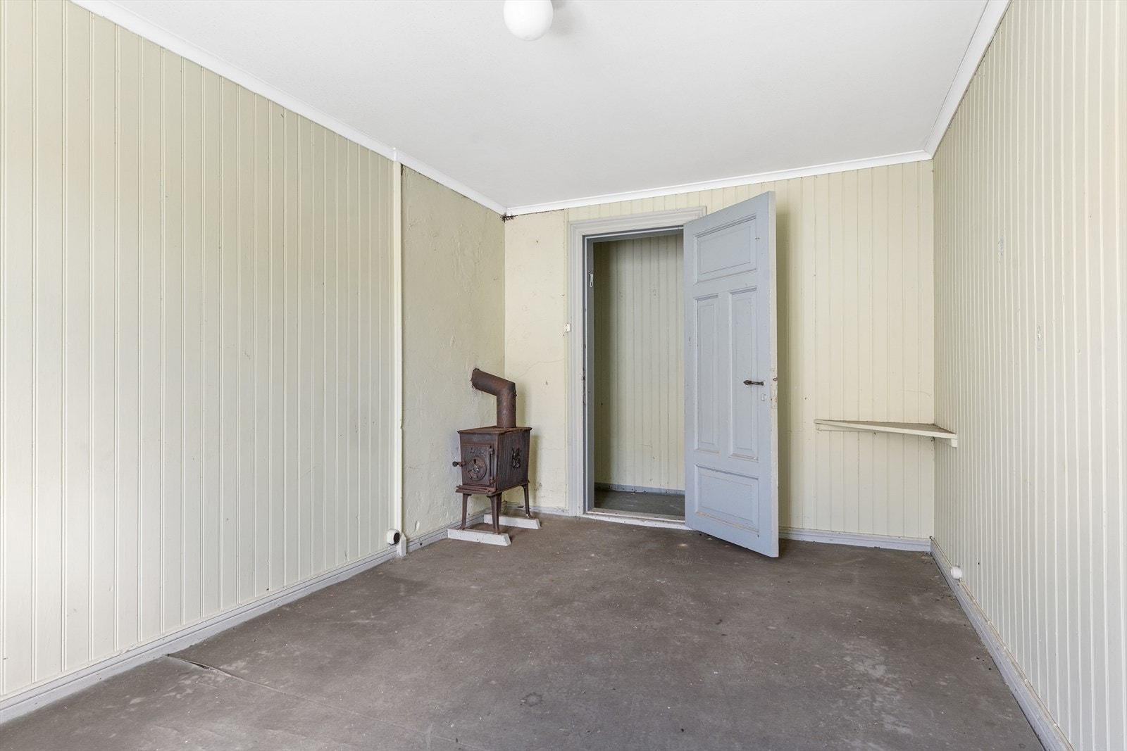 Rom med panelte vegger og vedovn. Galleribilde