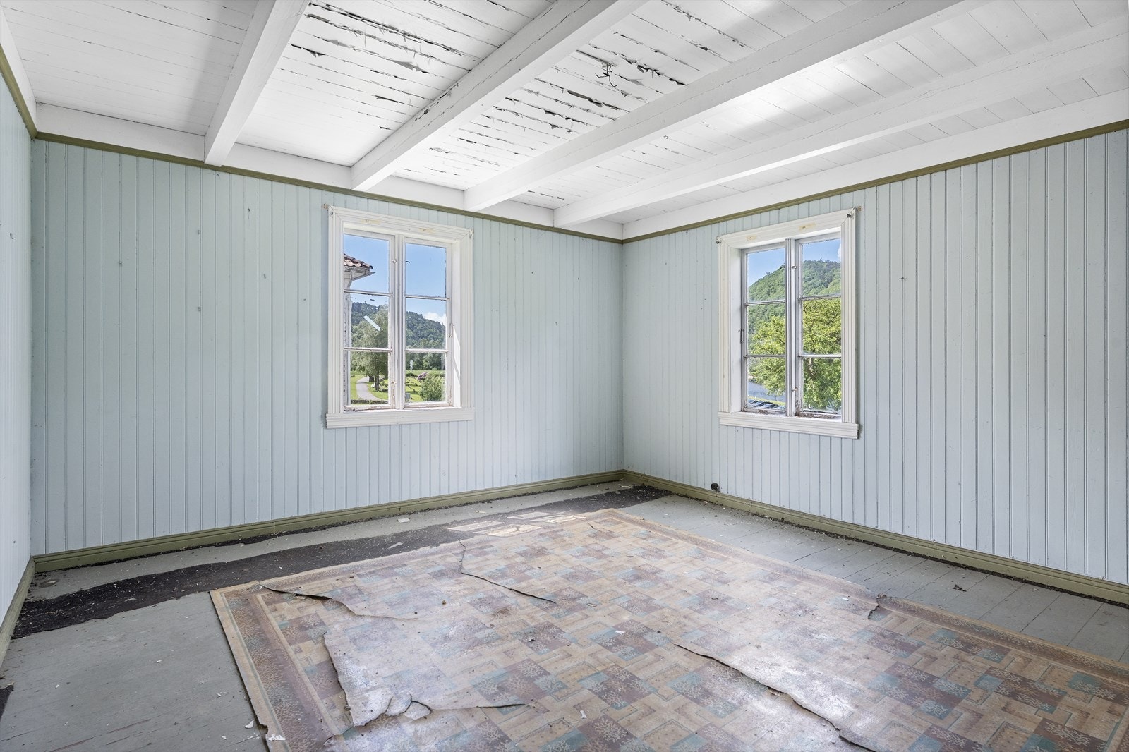 Stua med panel på veggene og eldre vinduer. Galleribilde