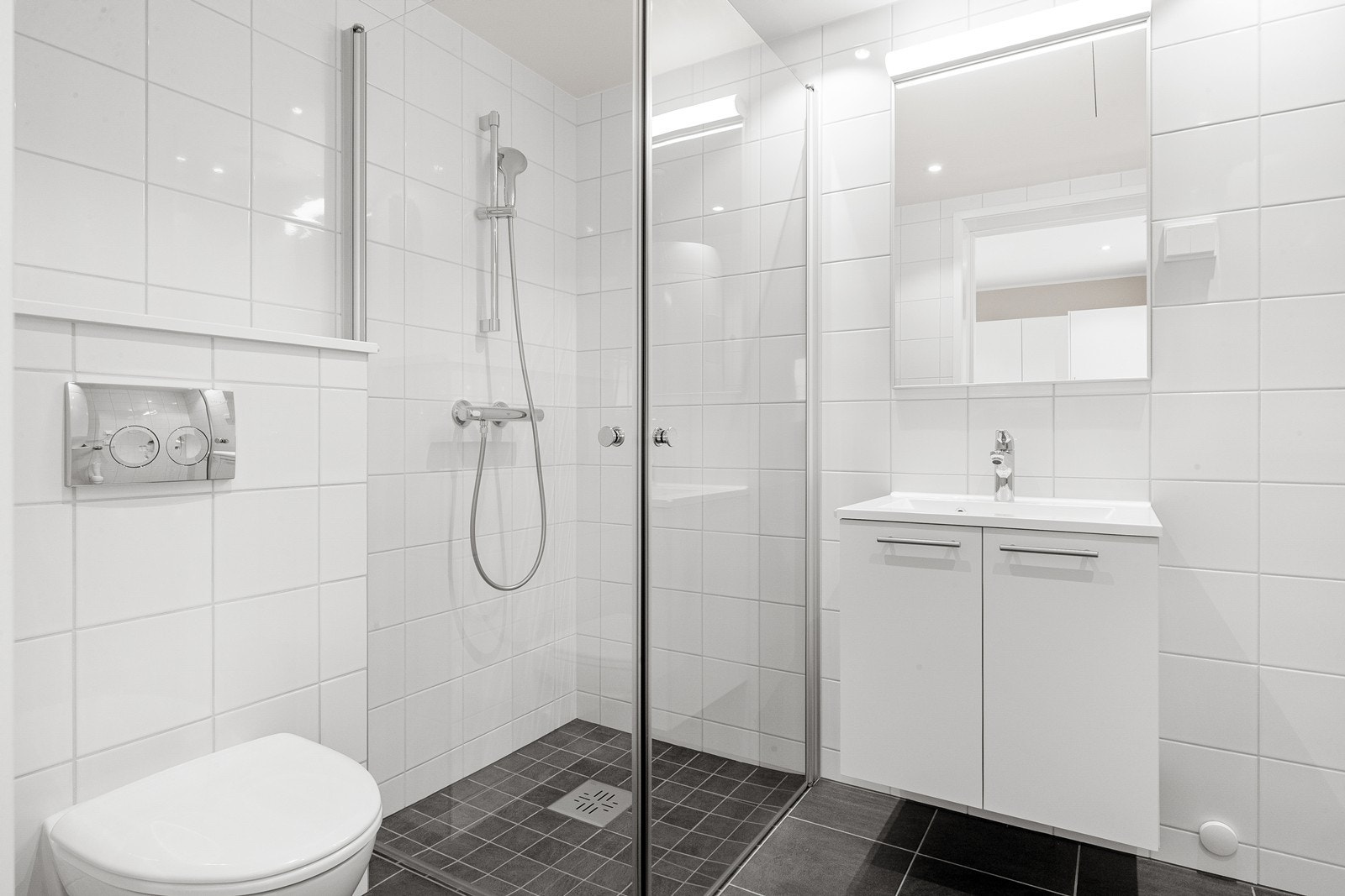 Badet er flislagt med dusjhjørne, opplegg for vaskemaskin Galleribilde