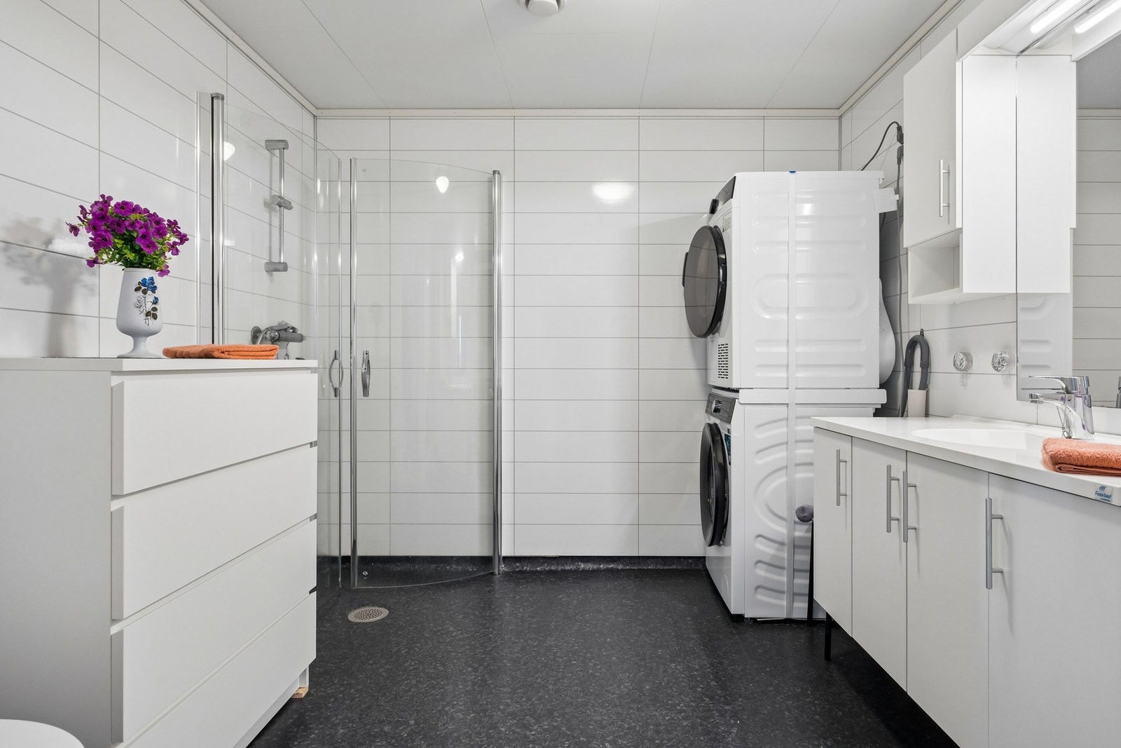 Romslig bad med gulvbelegg og opplegg for vaskemaskin. Varmekabler i gulv. Galleribilde