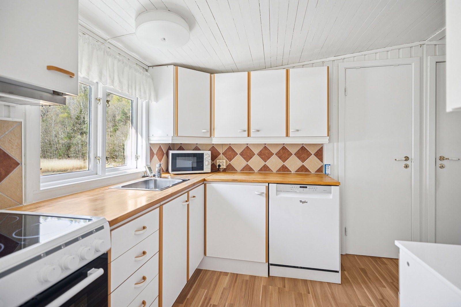 Kjøkkeninnredning fra IKEA med glatte fronter og heltre benkeplate, nedsenket oppvaskkum i rustfritt stål. Galleribilde