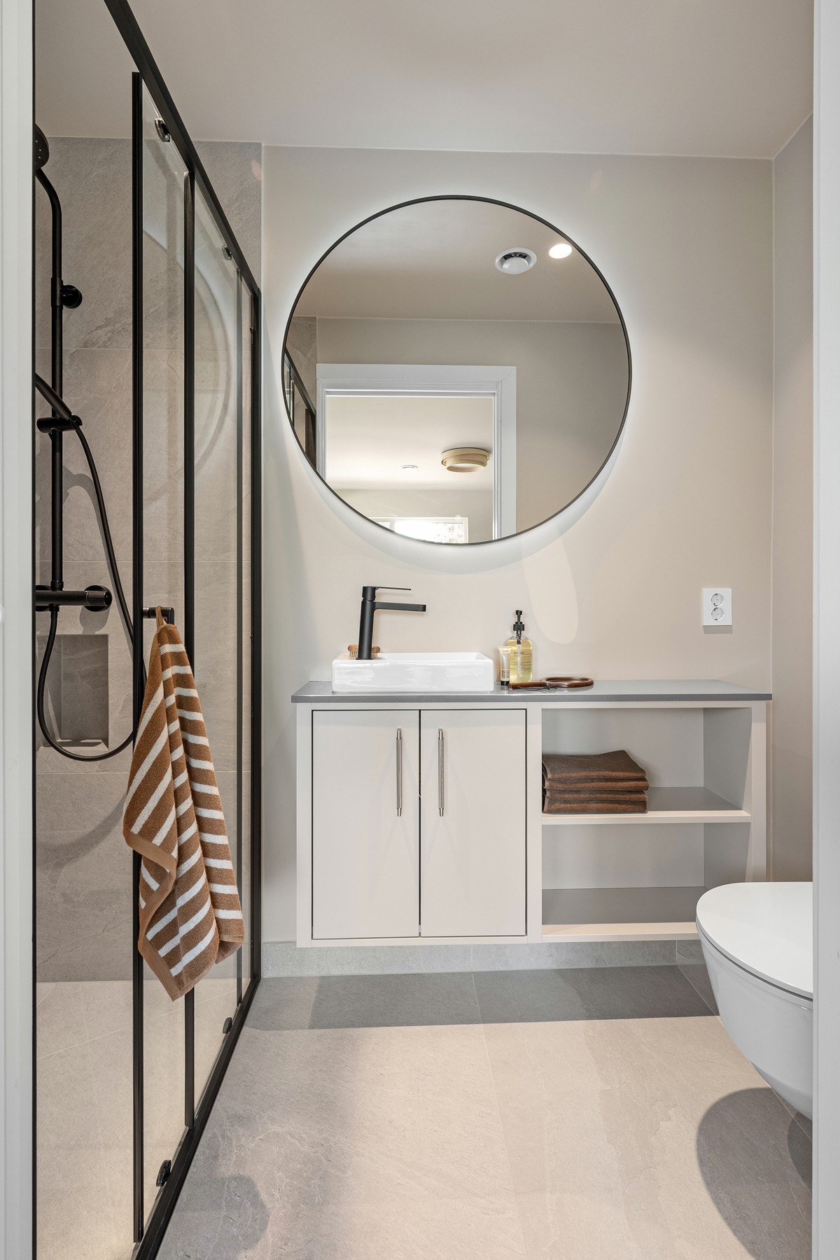 En-suite badet tilknyttet hovedsoverommet har moderne flislagte overflater, dusjnisje, vegghengt toalett og snekkerbygget servantinnredning. Galleribilde