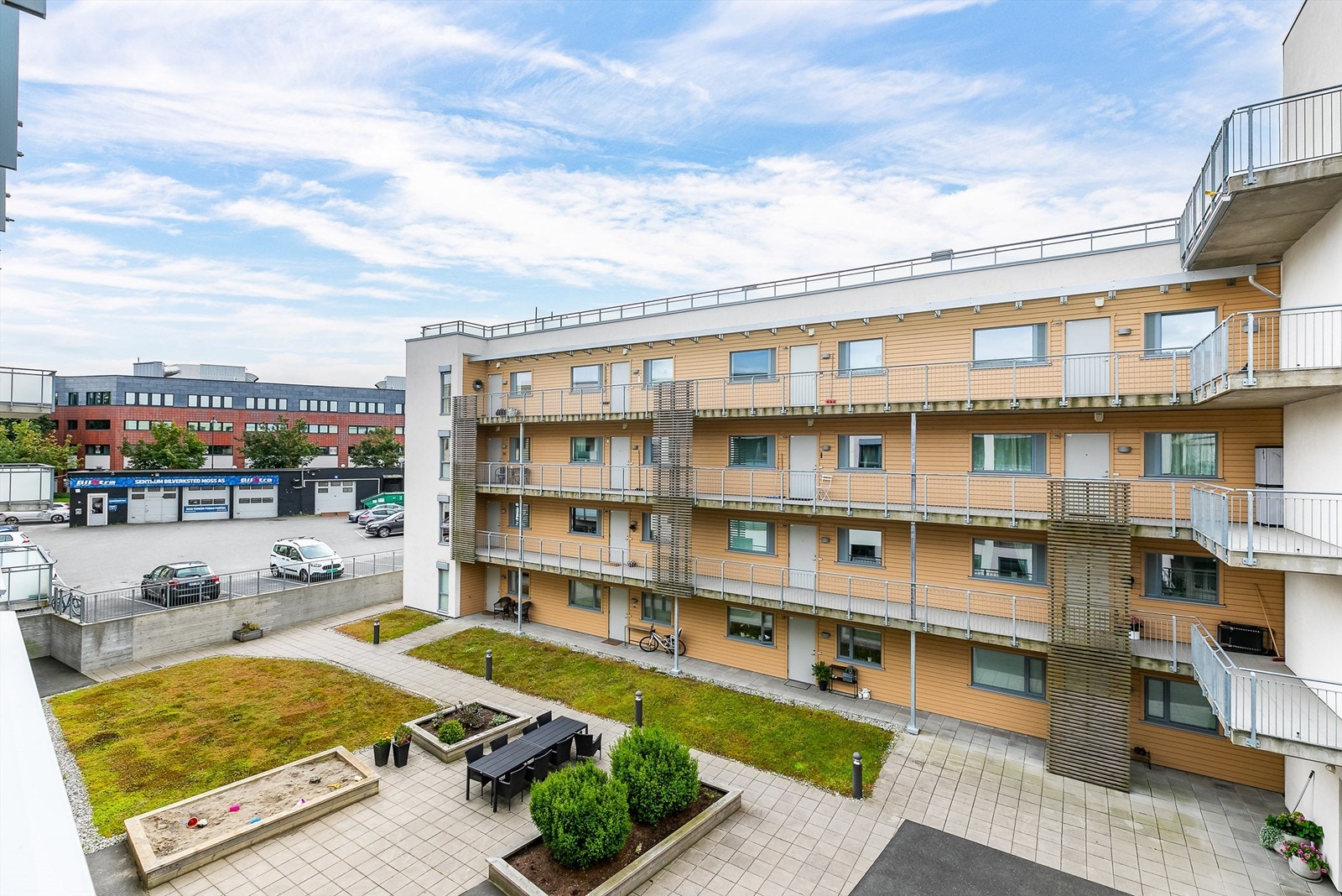 Utsyn fra verandaen over sameiets skjermede gårdsrom. Galleribilde