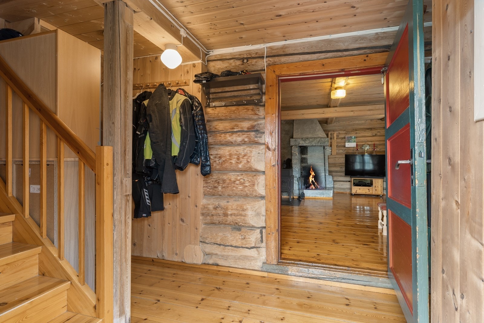 Fra entréen er det direkte inngang til stuen, hvor de solide tømmerveggene setter et autentisk preg. Galleribilde