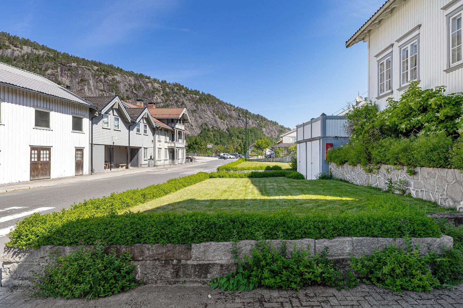 Foran boligen er det flotte plener med små hekker som preger gatene i Åmli sentrum. Galleribilde