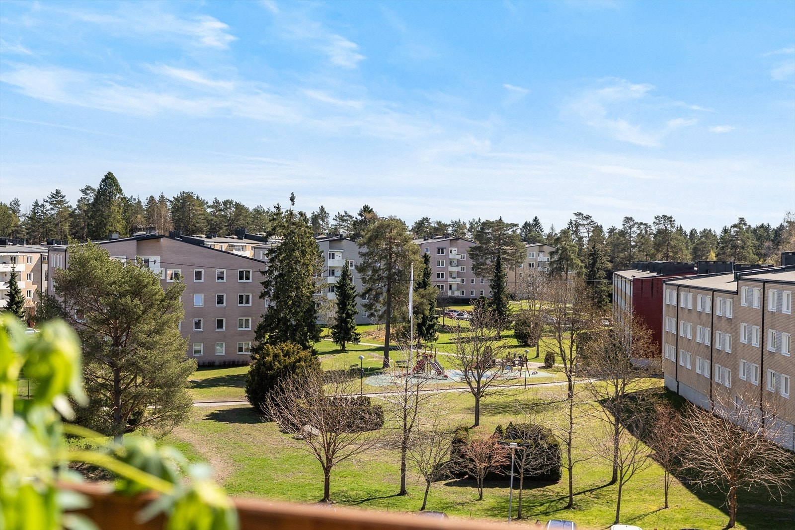Utsikt over et barnevennlig område med lekeplasser og store, grønne fellesarealer. Galleribilde