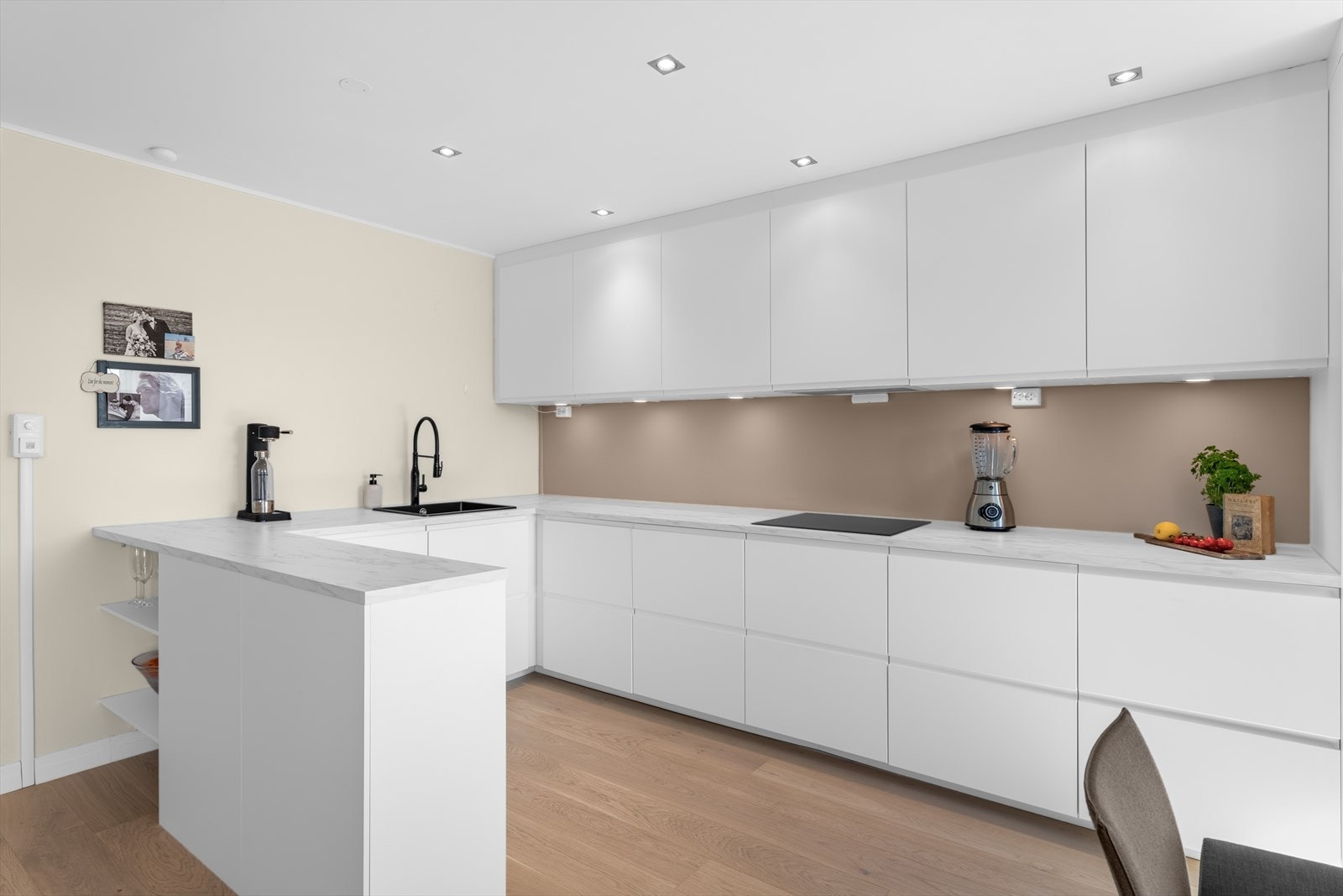 Leiligheten har kjøkkeninnredning fra 2022 med et rent og moderne uttrykk med glatte, folierte fronter og en benkeplate i laminat. Galleribilde