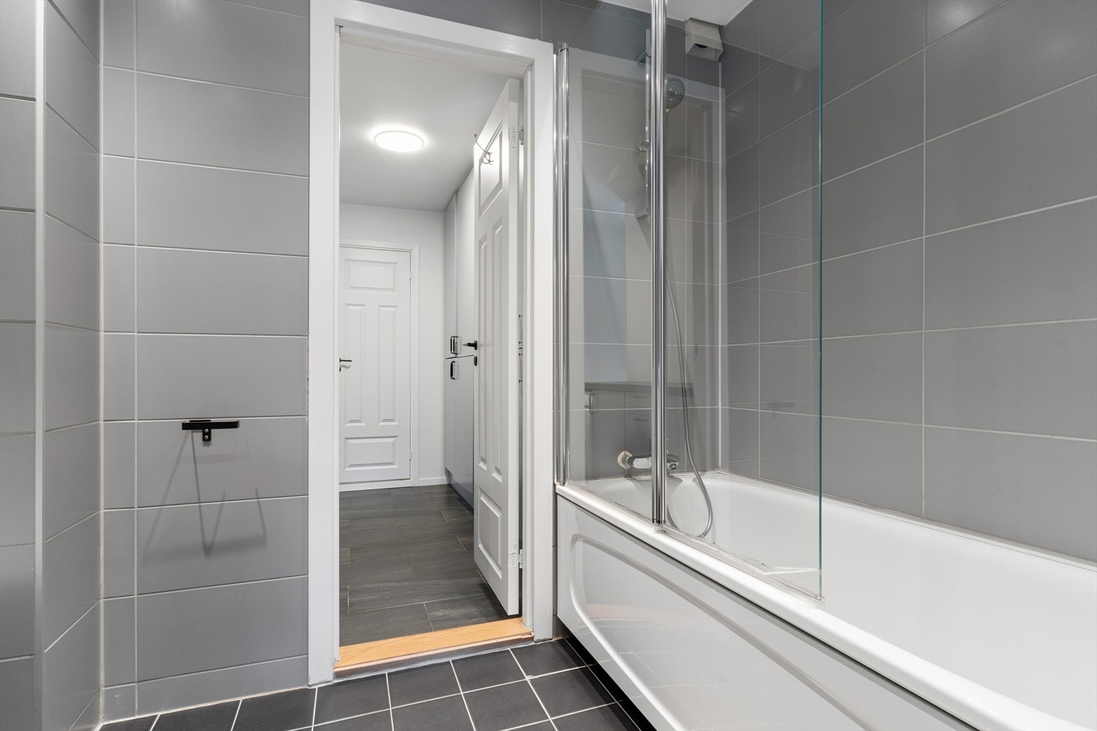 Det største badet fra 2018 er flislagt og innredet med nedfelt servant, toalett og badekar med glassvegg. Toalett og glassvegg til badekar ble skiftet i 2023. Galleribilde