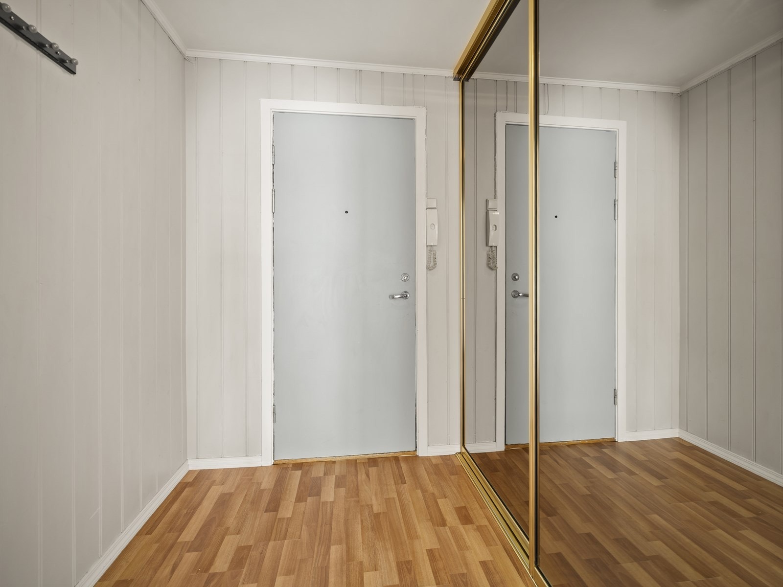 Romslig entré med stor skyvedørsgarderobe med speilfronter. Galleribilde