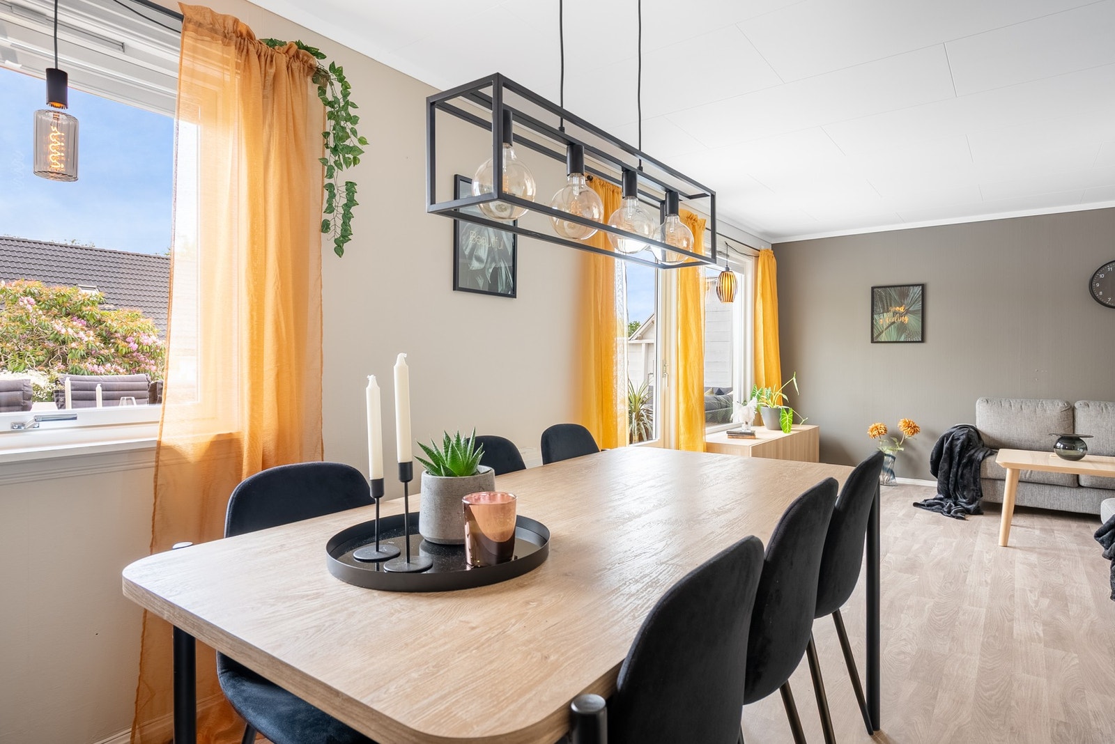 De store vinduene mot uteplassen fyller rommet med naturlig lys og skaper en behagelig kontakt med uteområdet Galleribilde