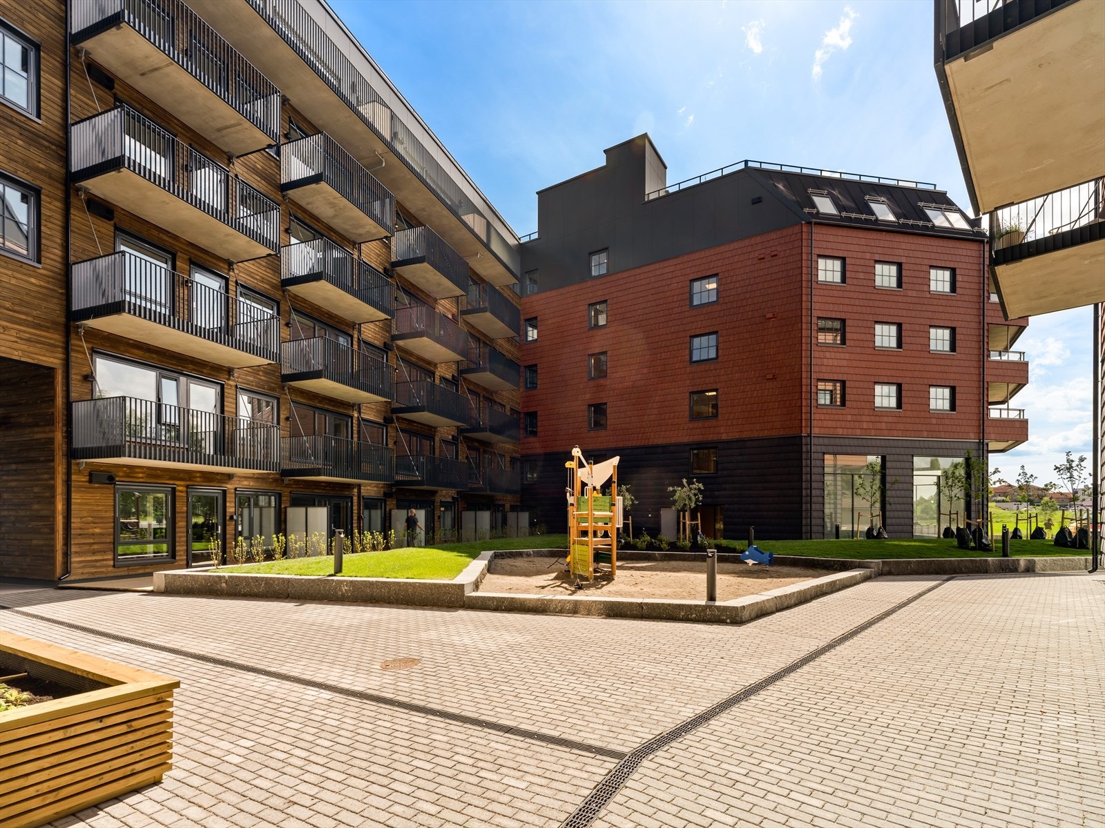 Hyggelig felles gårdsrom med plen og lekeapparater Galleribilde