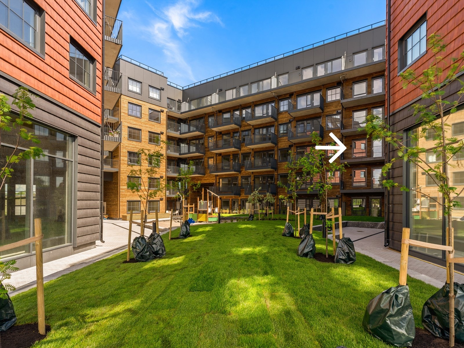 Sameiet har en hyggelig og skjermet bakgård med plen og lekeapparater Galleribilde