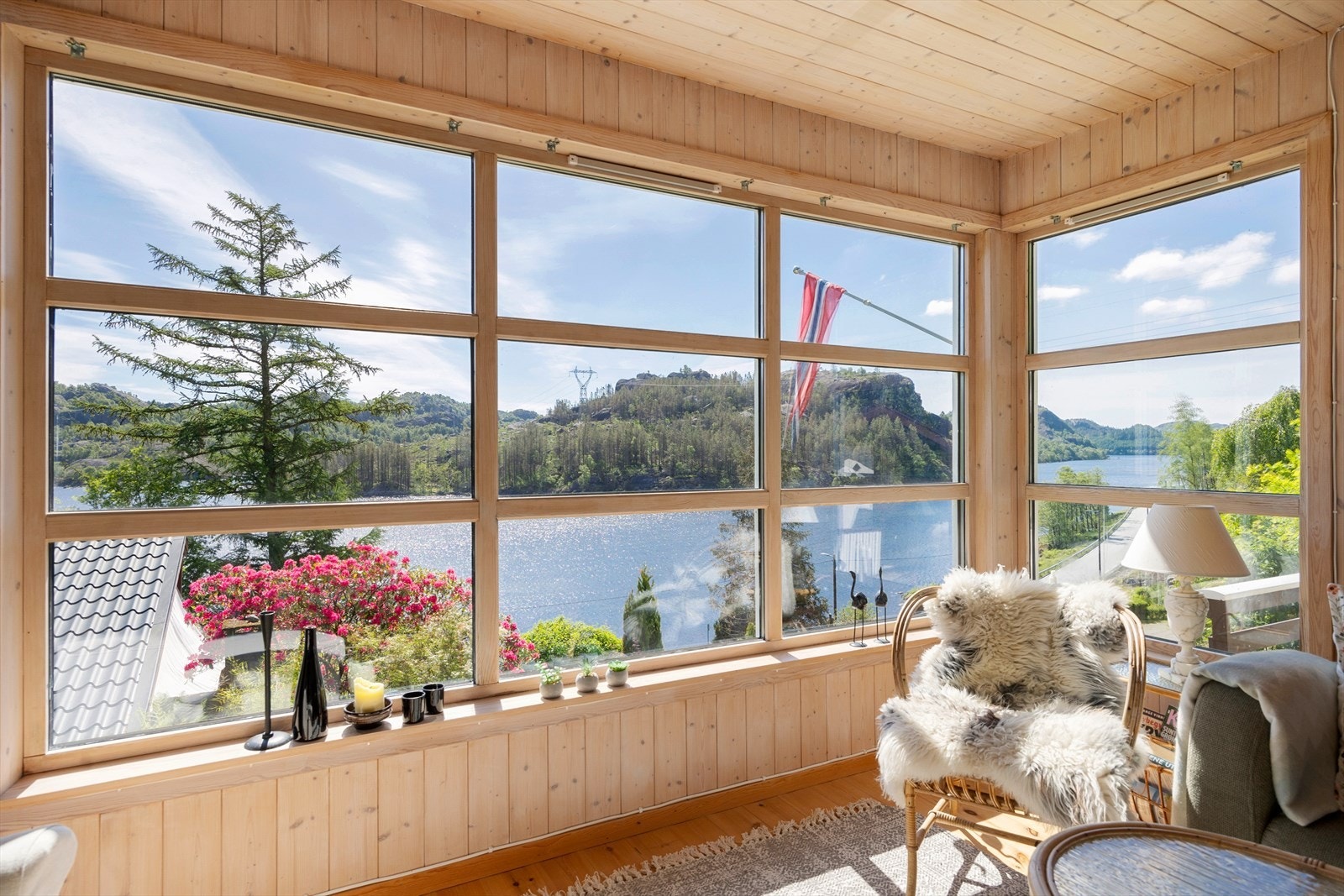 Store vindusflater i stuen rammer inn utsikten over vannet. Galleribilde