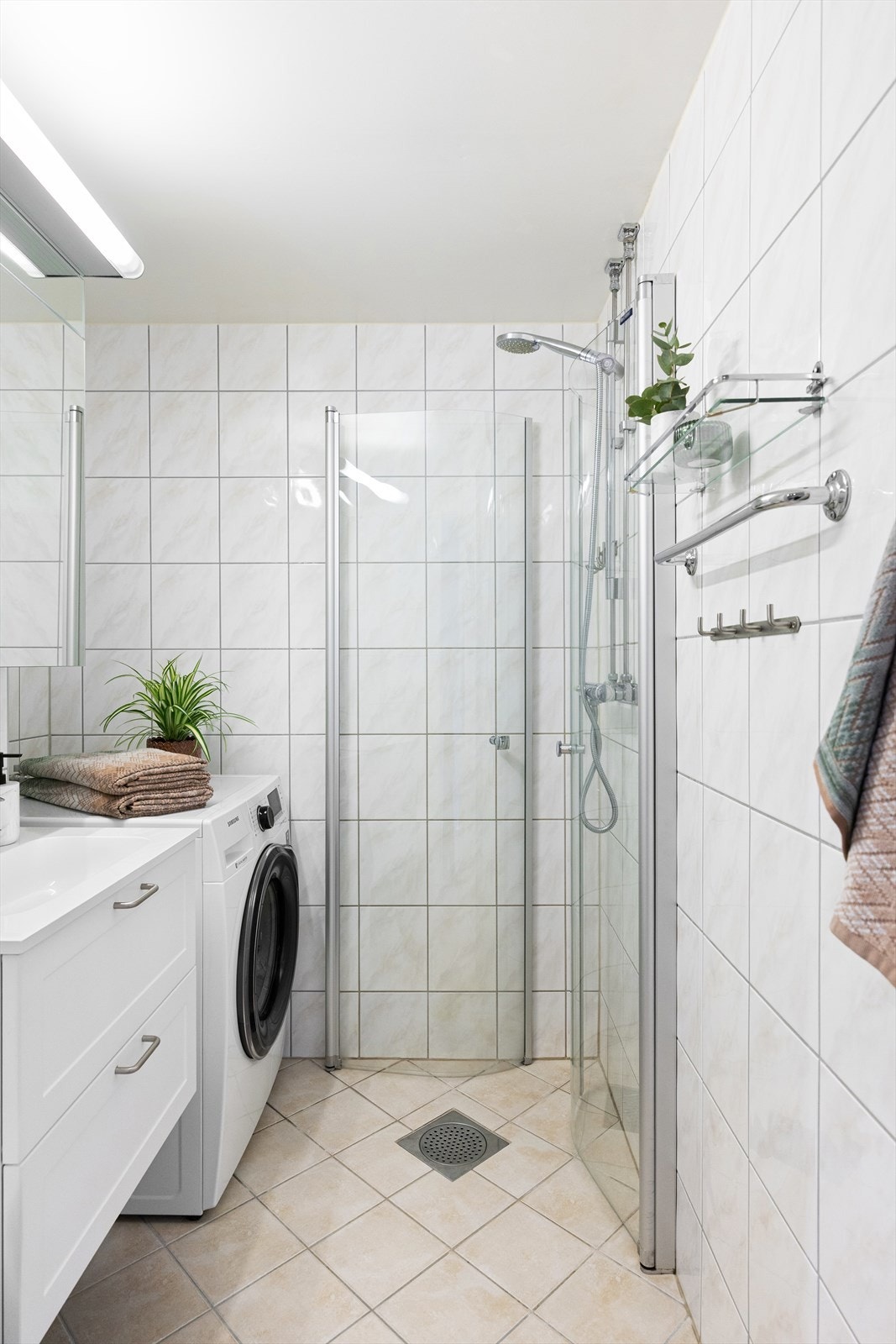 Badet består av servantskap med nedfelt servant (ny i 2024), veggskap med speildører og lys over, vegghengt klosett med innebygd sisterne og dusjsone med innfelte dusjdører i herdet glass. Galleribilde