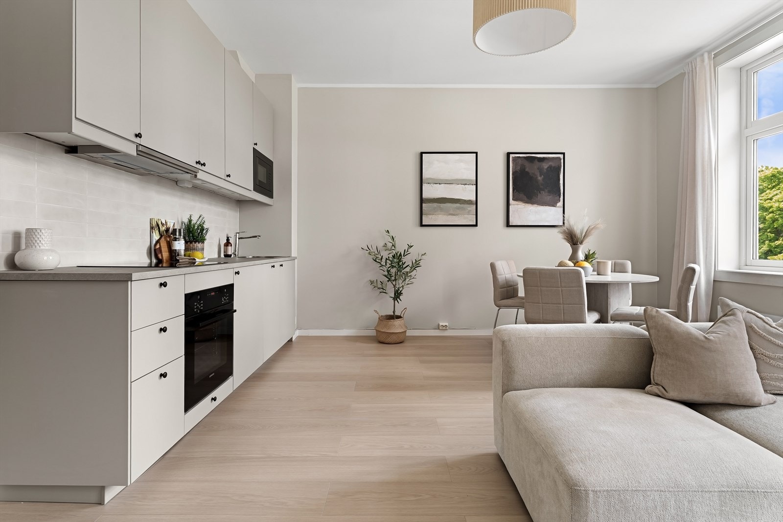 Kjøkkeninnredning med matte, glatte fronter og fliser over benkeplaten. Galleribilde