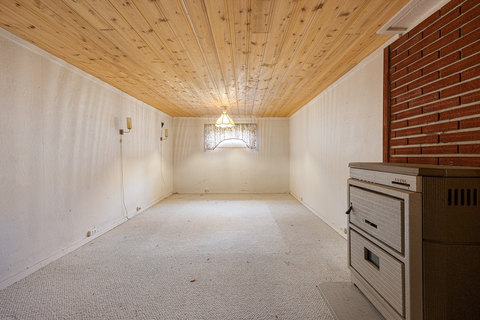 Stort, innredet rom i kjelleren med en kombinert ved- og oljekamin. Takhøyden i kjelleren er målt til ca. 2,00-2,05 meter. Galleribilde