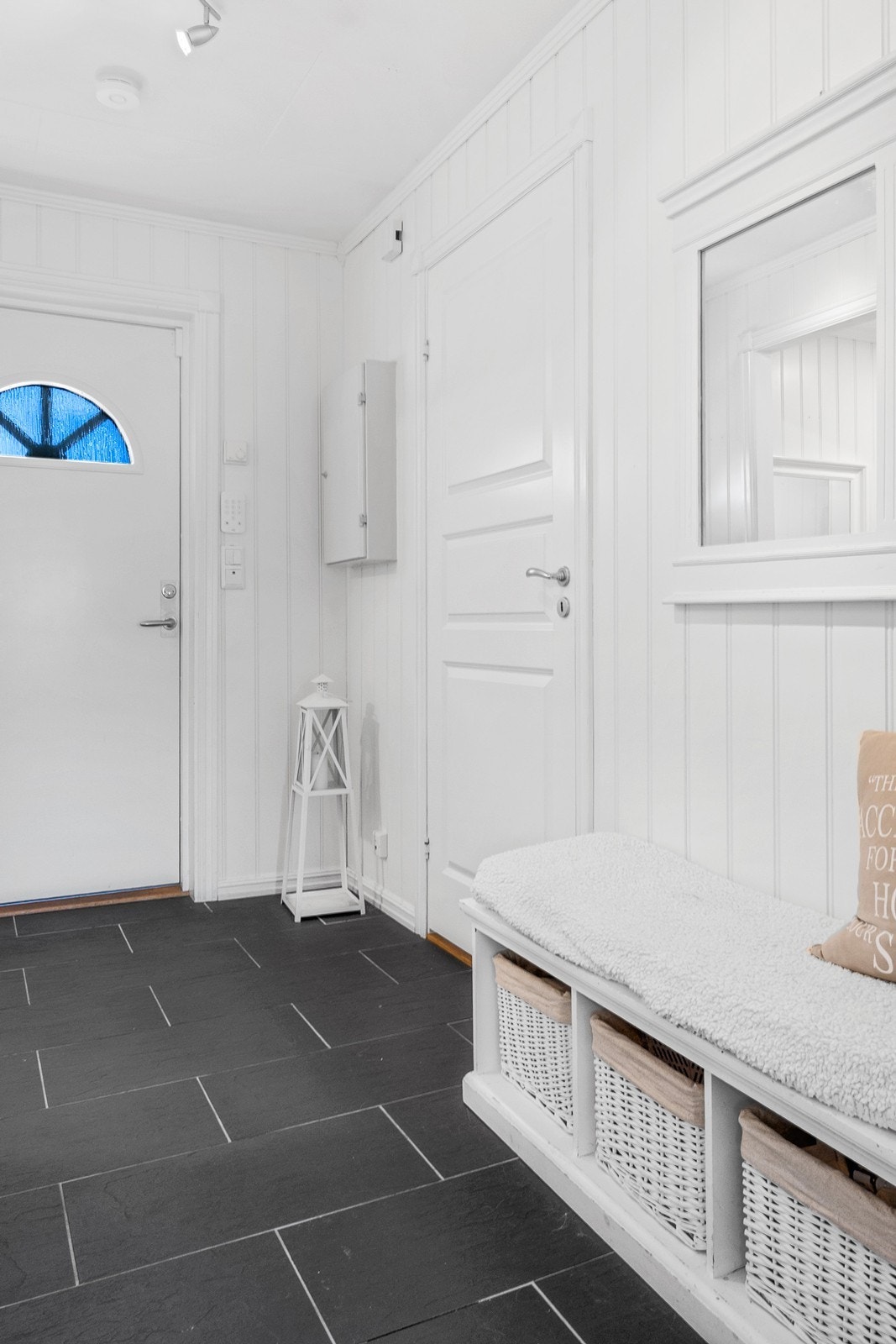 Vel inne er en flislagt entré med gulvvarme og plass til oppbevaringsmøbel. Galleribilde