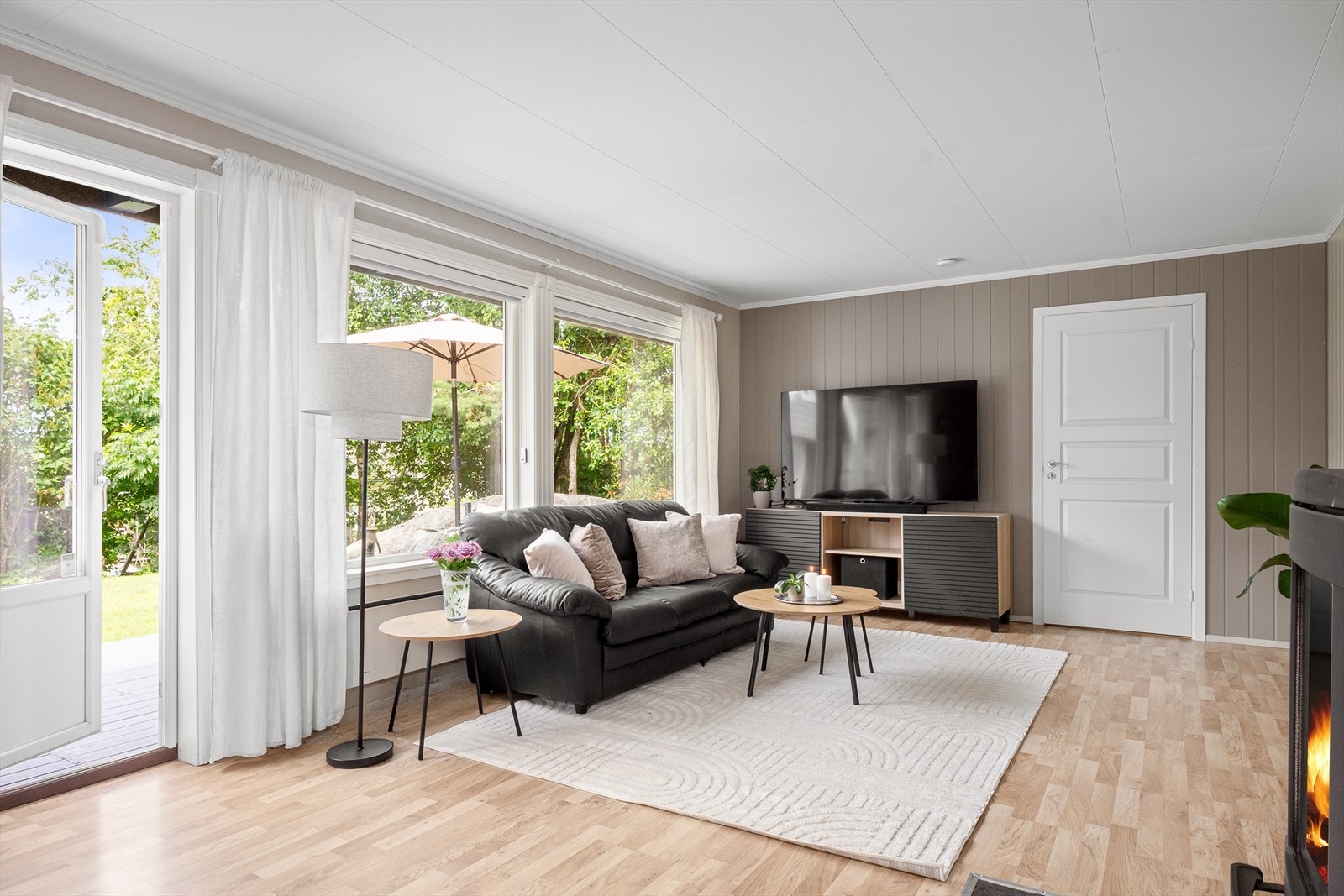En koselig vedovn sentralt i rommet bidrar til varme, og terrassedør fører til uteplass på baksiden. Galleribilde