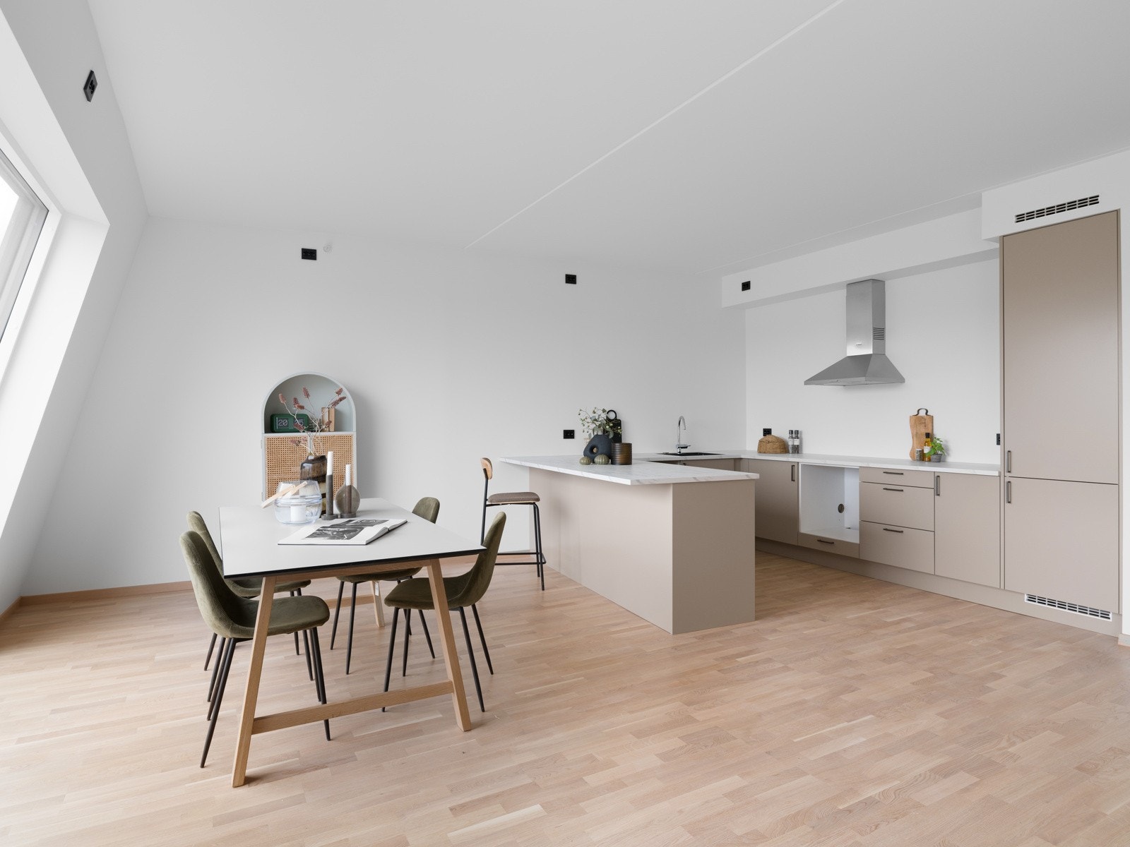 Ved den ene delen av innredningen er det tilrettelagt for en praktisk sitteplass, perfekt for en rask frokost eller hyggelige samtaler under matlagingen. Galleribilde