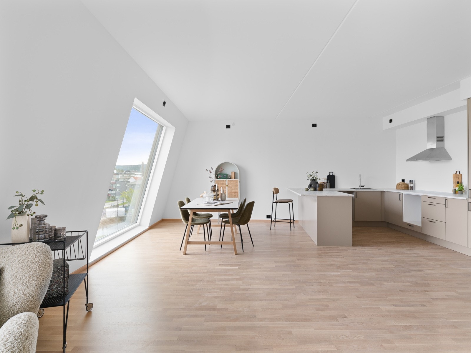 Kjøkkenet fremstår moderne og funksjonelt med stilrene, slette fronter og benkeplate i høytrykklaminat med underlimt vask. Galleribilde