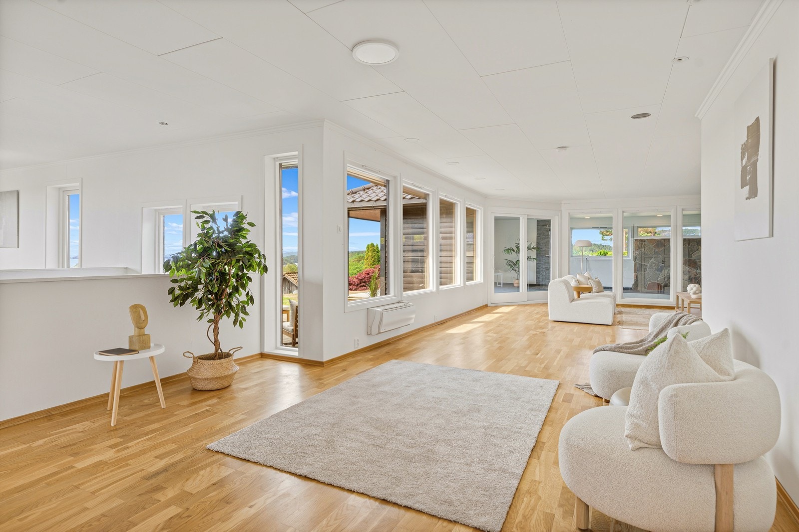 Den romslige stuen har store vindusflater som slipper inn rikelig med dagslys og lar den fantastiske utsikten bli en naturlig del av rommet Galleribilde