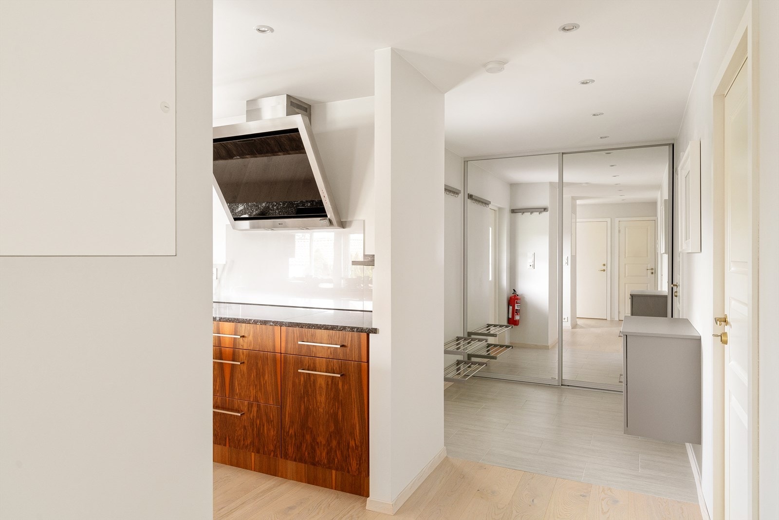 Stor og praktisk gang med skyvedørsgarderobe i speil, spotbelysning og flislagt gulv med varmekabler. Galleribilde