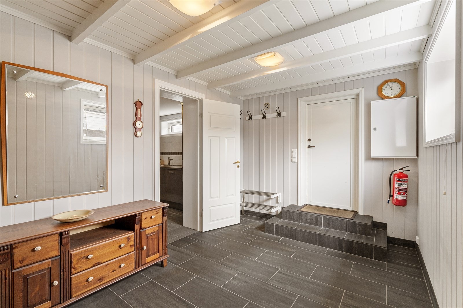 Romslig entré i kjelleretasjen med flislagt gulv og god plass til yttertøy. Galleribilde