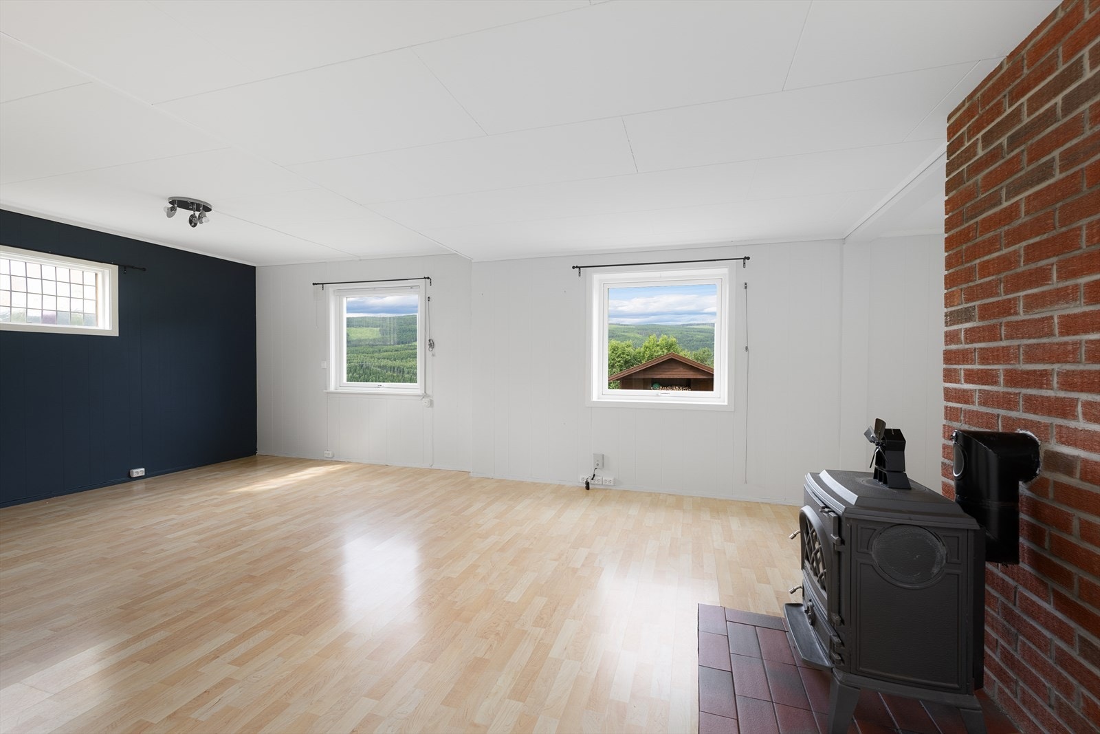 Stuen har laminatgulv og vinduer som gir lys fra flere kanter. Galleribilde