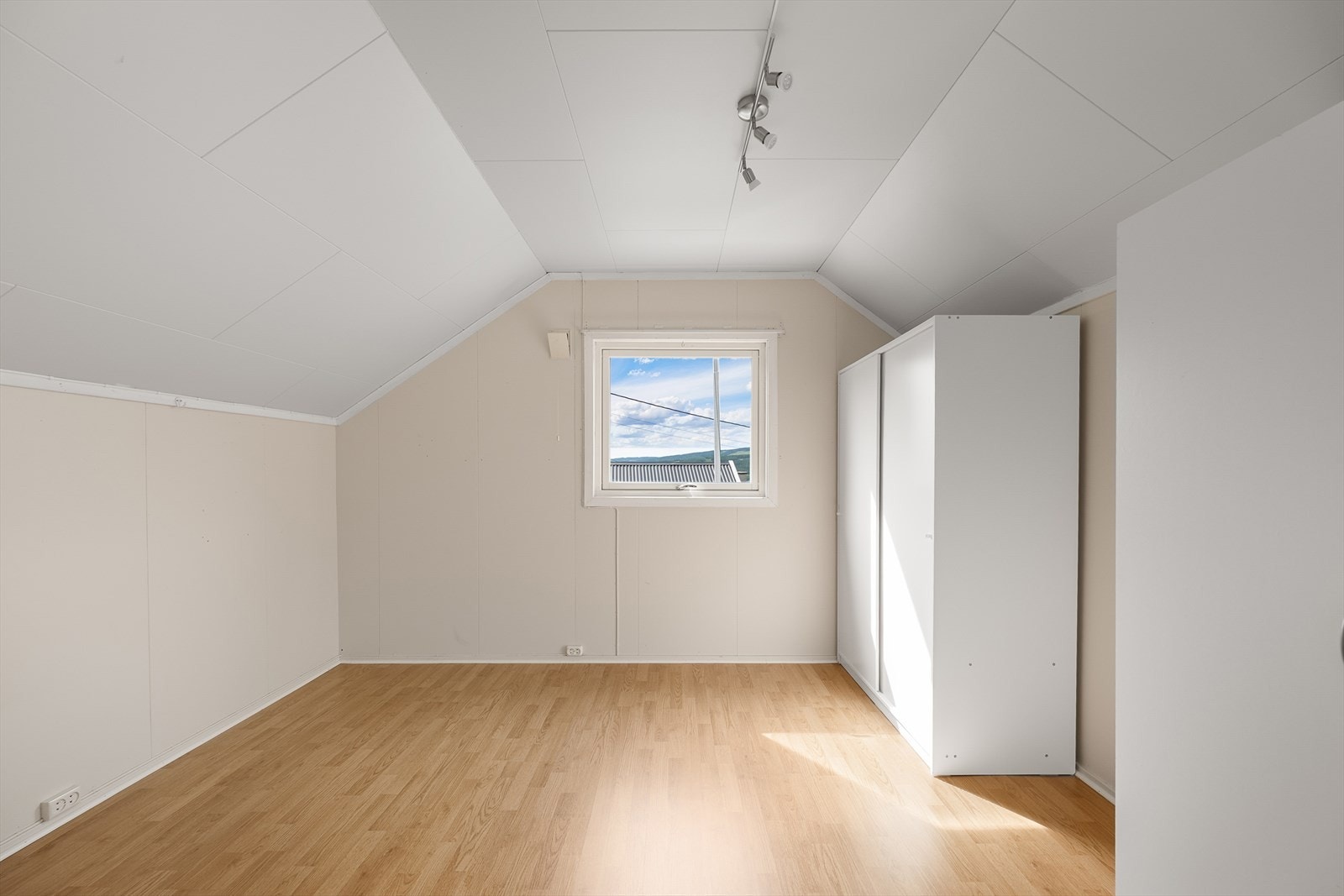 Soverom i andre etasje med skråtak og laminatgulv. Galleribilde