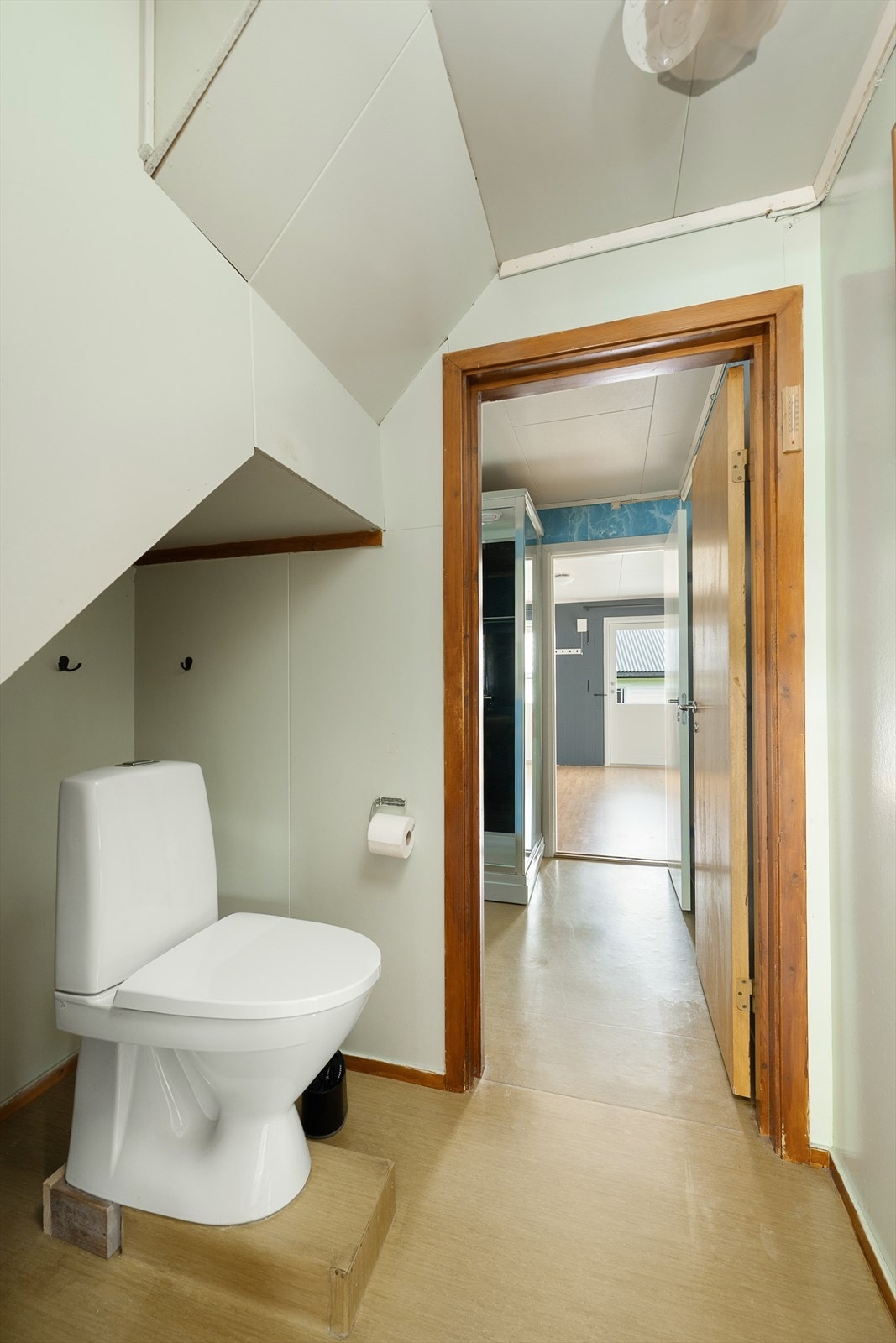 Separat toalettrom under trappen som har gjennomgang til badet, utstyrt med gulvmontert WC. Galleribilde