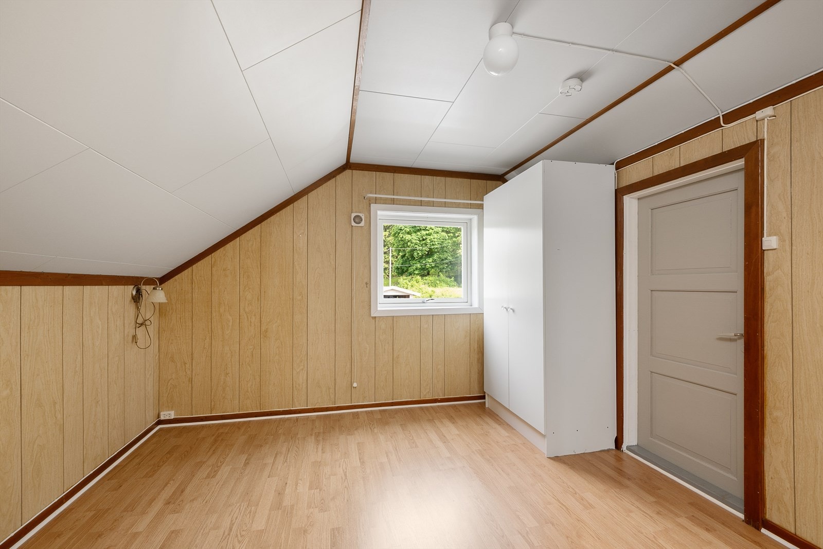 Det andre soverommet i etasjen har vegger med trefiberplater. Galleribilde