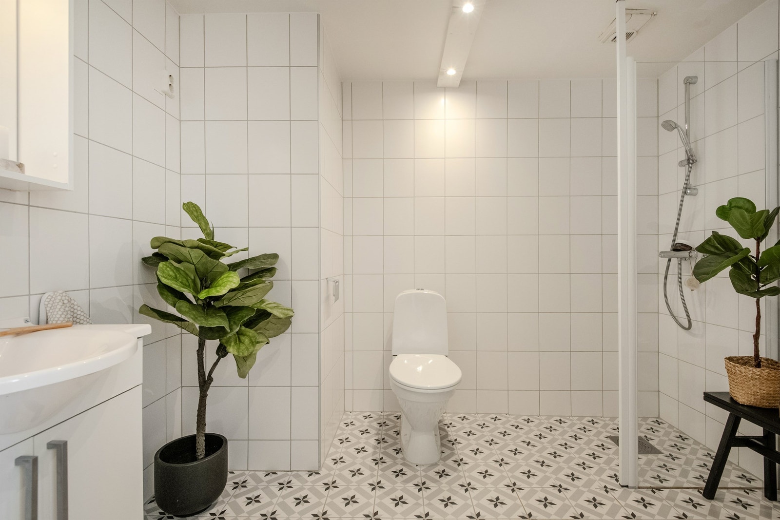 Tidløst flislagt bad av god størrelse. Her har man og plass til oppbevaring eller ønsket møblement til høyre for dusjhjørnet. Galleribilde