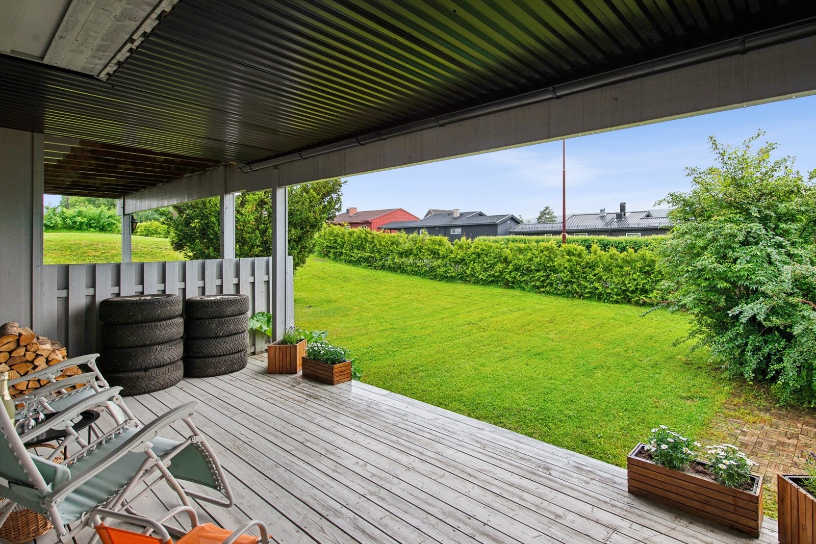 Den store, overbygde terrasseplattingen gir en lun uteplass med direkte tilgang til hagen. Galleribilde