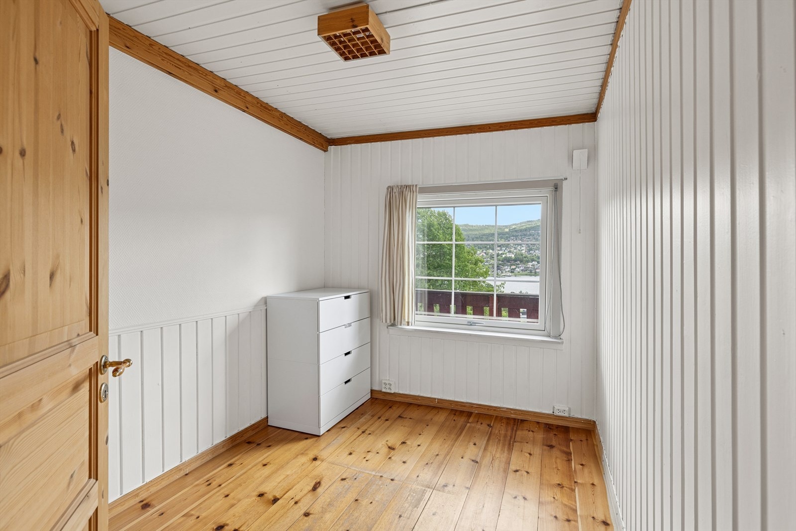 Det andre soverommet i første etasje har tregulv og panel på veggene. Galleribilde