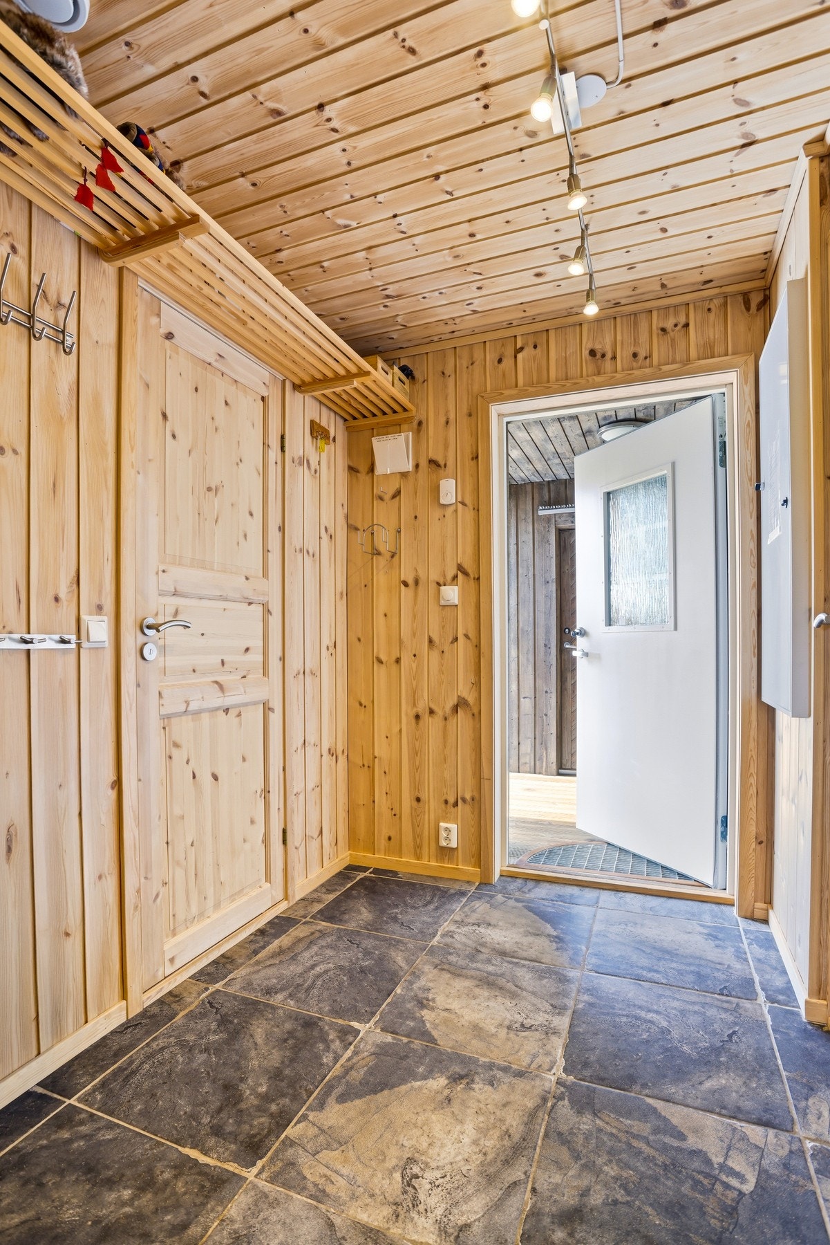 Velkommen inn! Romslig entré med flislagt gulv og god plass til yttertøy Galleribilde