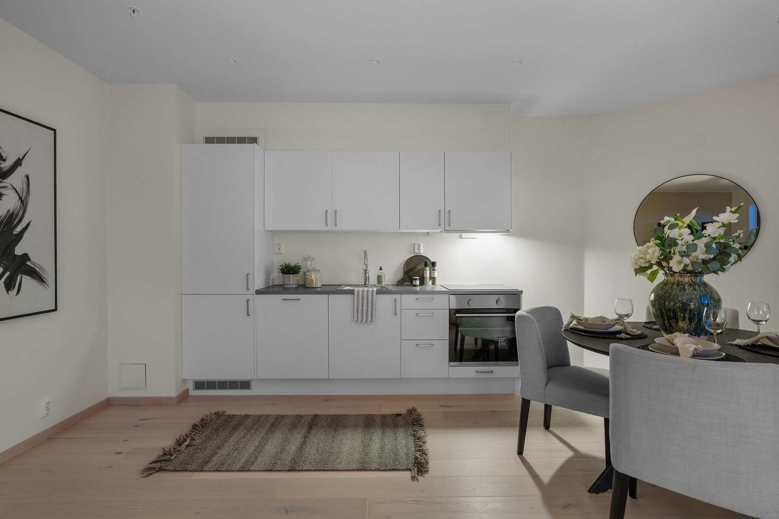 Stilrent kjøkken med slette fronter, integrerte hvitevarer og gode arbeidsflater for en effektiv kjøkkenhverdag. Galleribilde