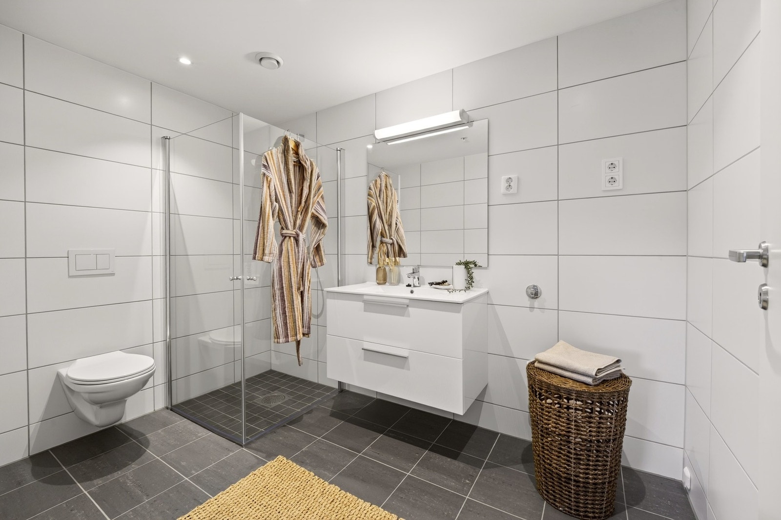 Badet fremstår moderne og delikat. Rommet er innredet med flislagte gulv og vegger, malt himling samt behagelig gulvvarme som bidrar til god komfort. Galleribilde