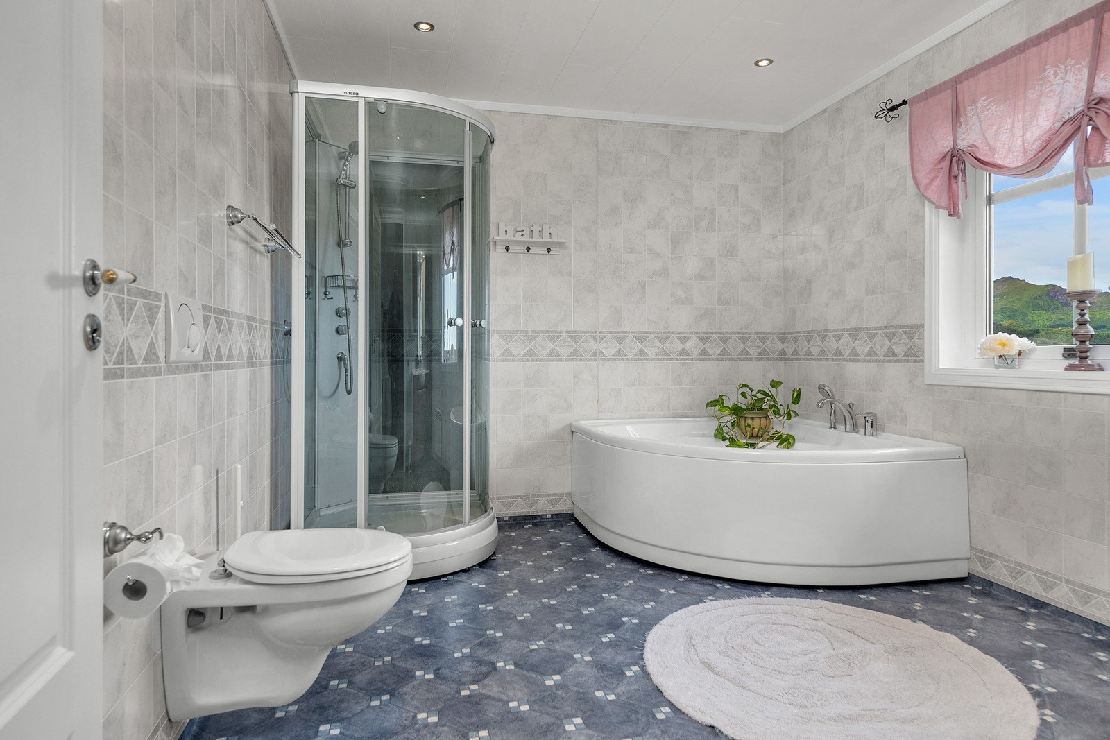 Badet inneholder dusjkabinett, badekar, vegghengt toalett og baderomsinnredning Galleribilde