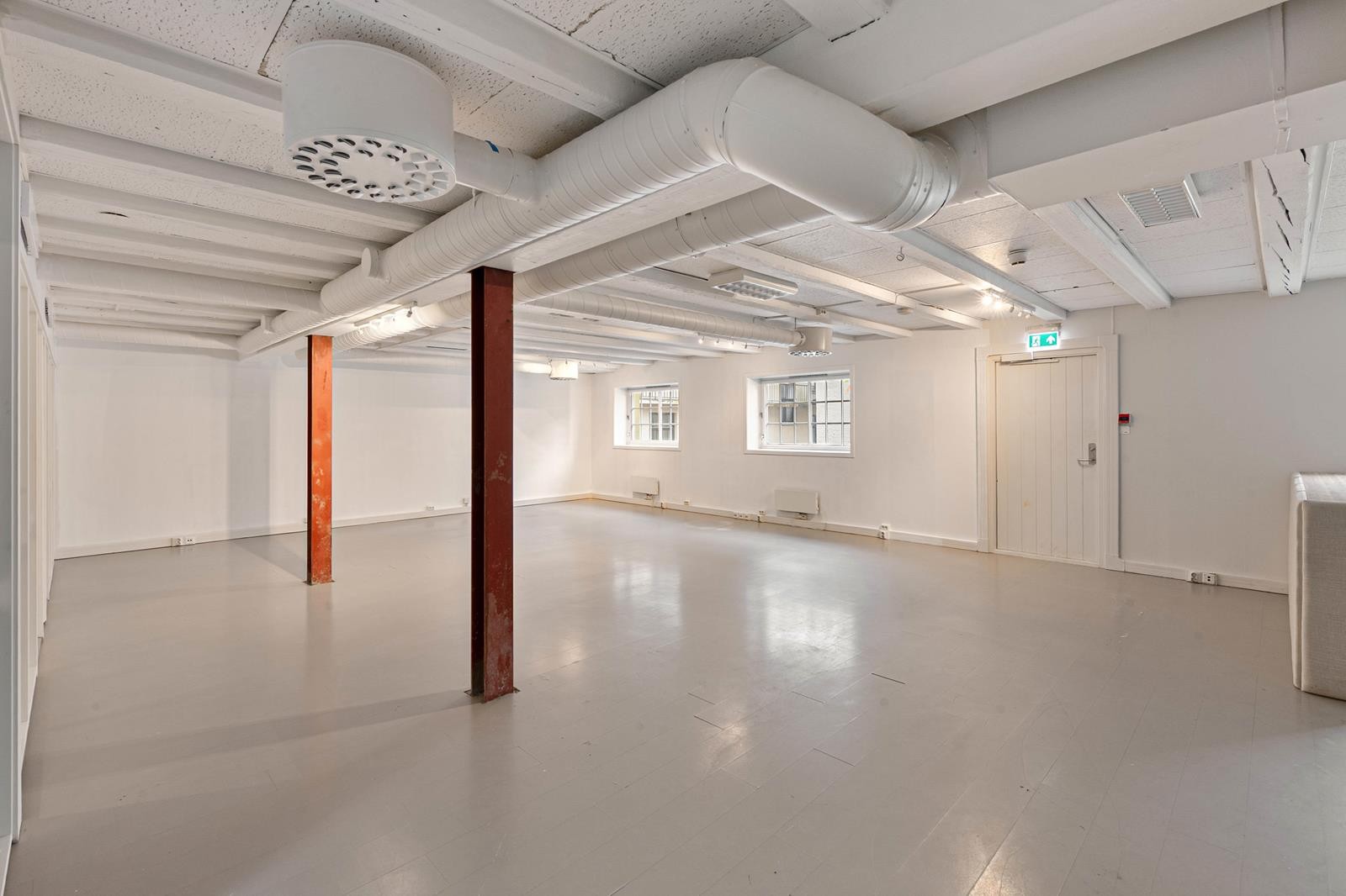 Kontoret er stort åpent. Vinduer og rømningsvei mot bakgård Galleribilde