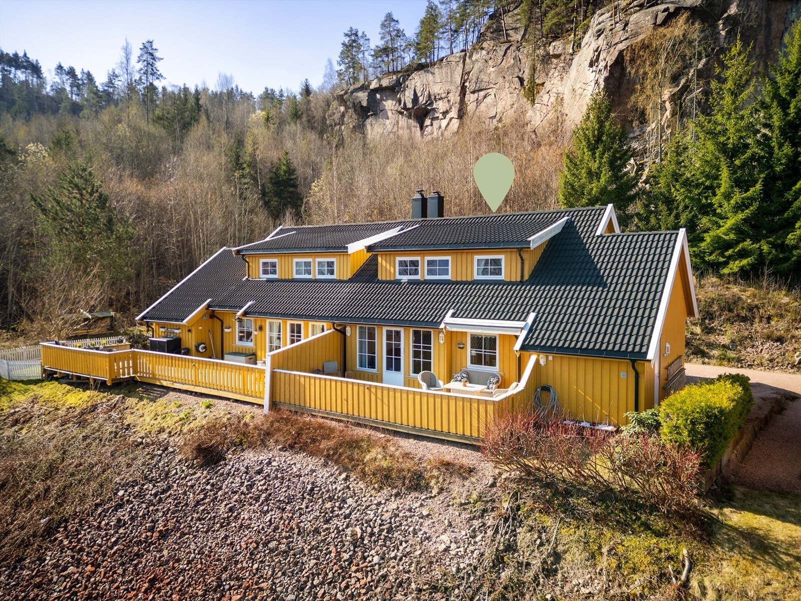 Tomten er opparbeidet med noe gressplen med diverse beplantninger og gruset gårdsplass. Galleribilde