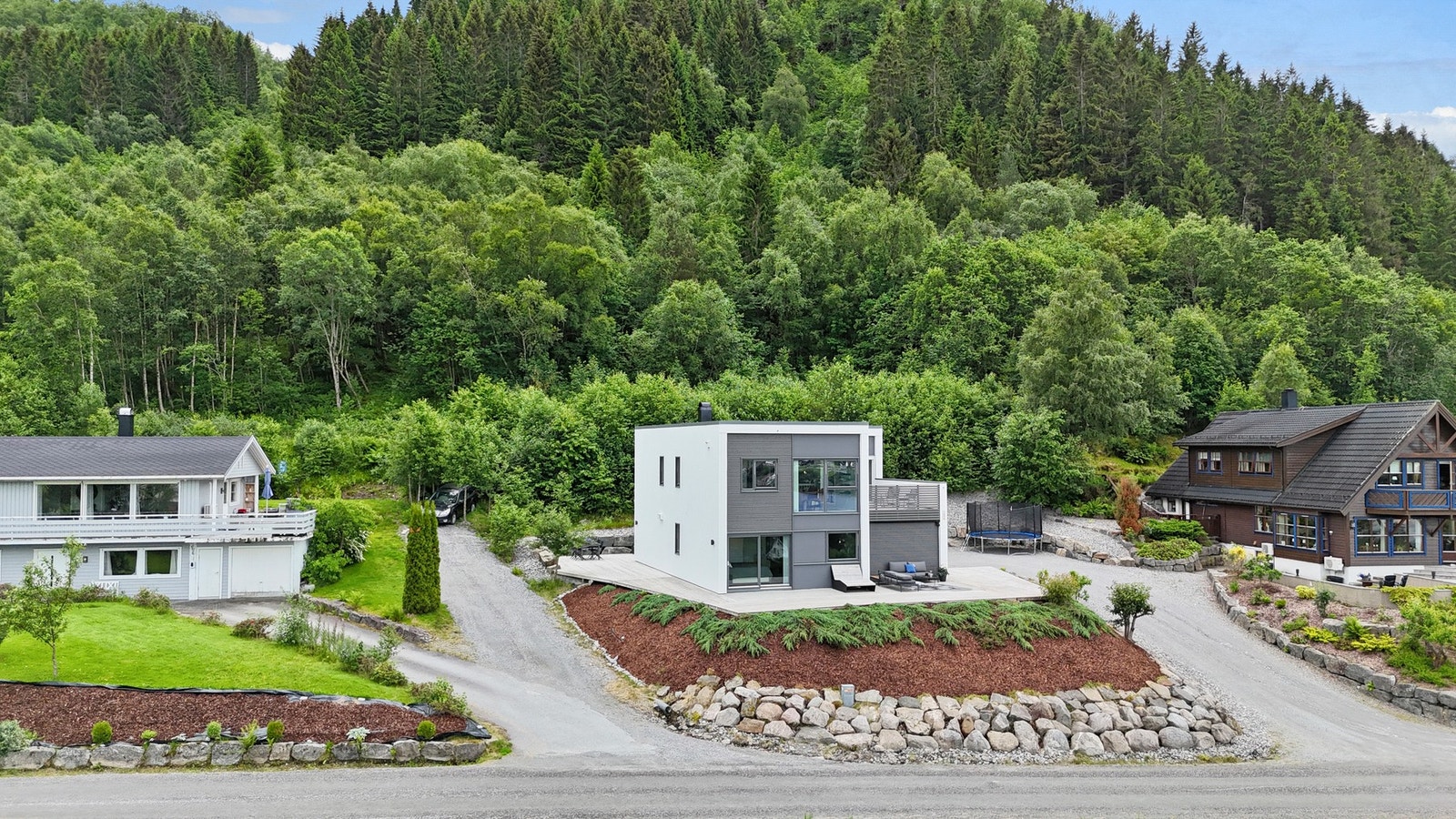 Tomten er opparbeidet med singlet/gruset adkomst og stor biloppstillingsplass. Ellers er tomten opparbeidet med store terrasser, forstøtningsmurer i naturstein og diverse beplantning. Galleribilde