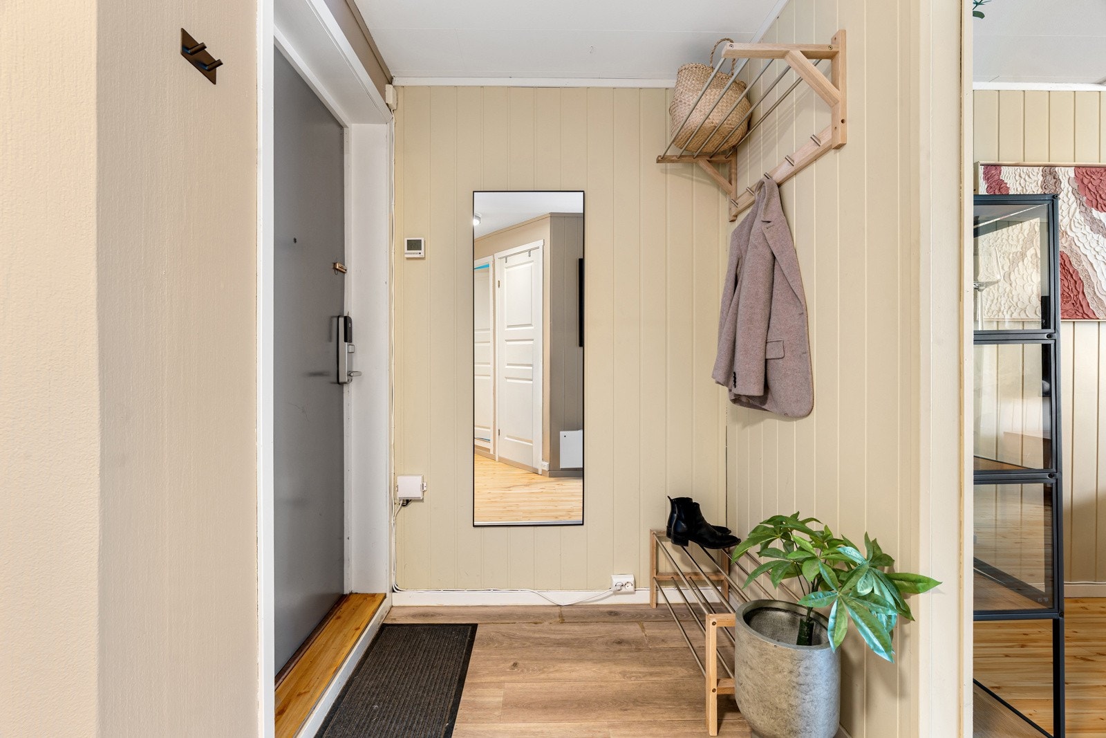 Entré med plass til skohylle og garderobeløsning. Det er også en innvendig bod i leiligheten.