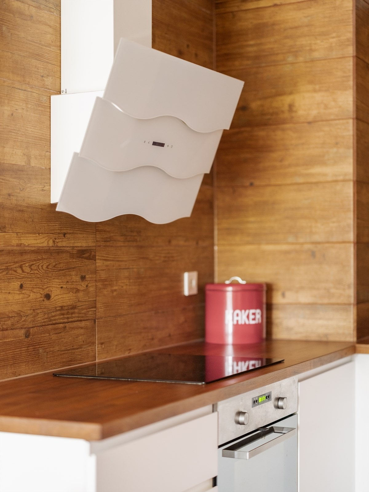 Kjøkkenventilator med kullfilter over induksjonstoppen. Galleribilde