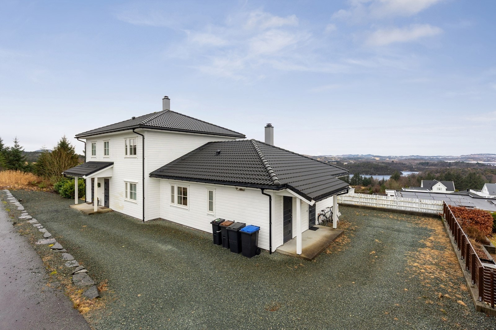 Eiendommen har en stor, gruset gårdsplass og separate innganger til begge boenhetene. Galleribilde